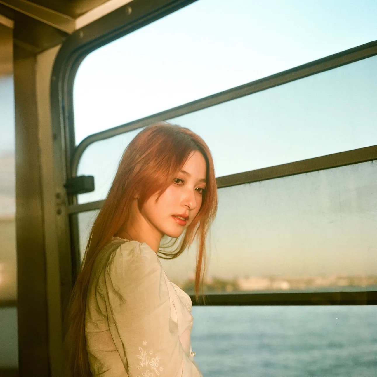 A portrait framed by green ferry windows.