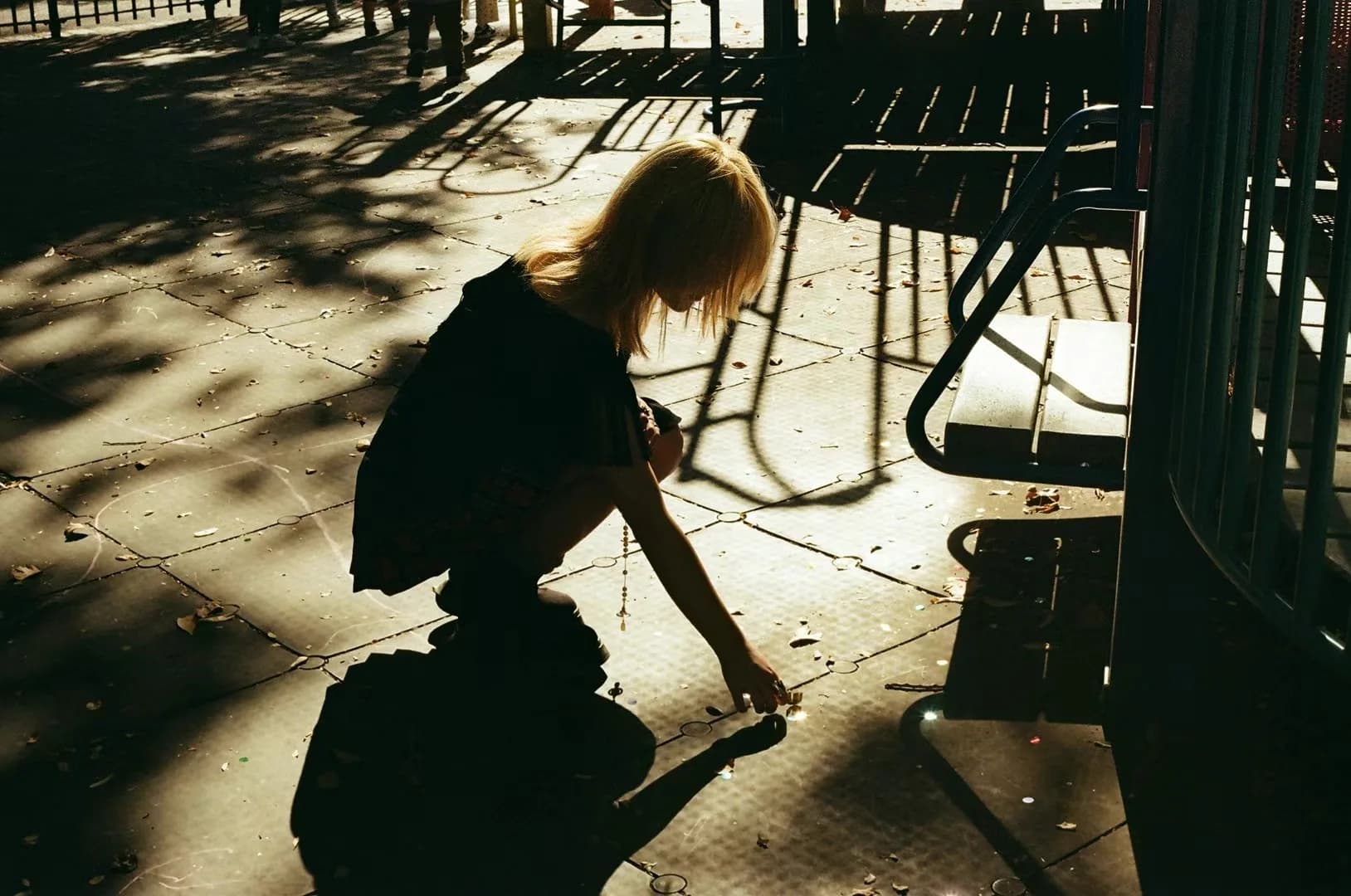 A figure and hard shadows outside a cafe.