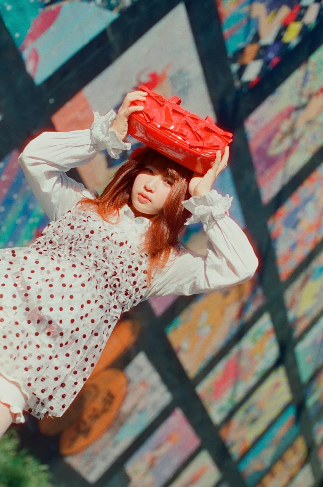 A red headpiece against a multicolor mural.
