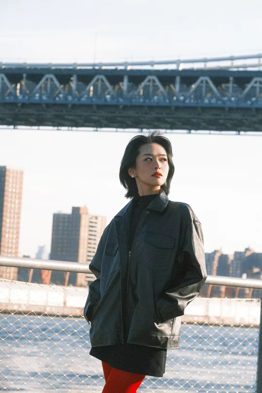 A waterfront portrait beneath a bridge.