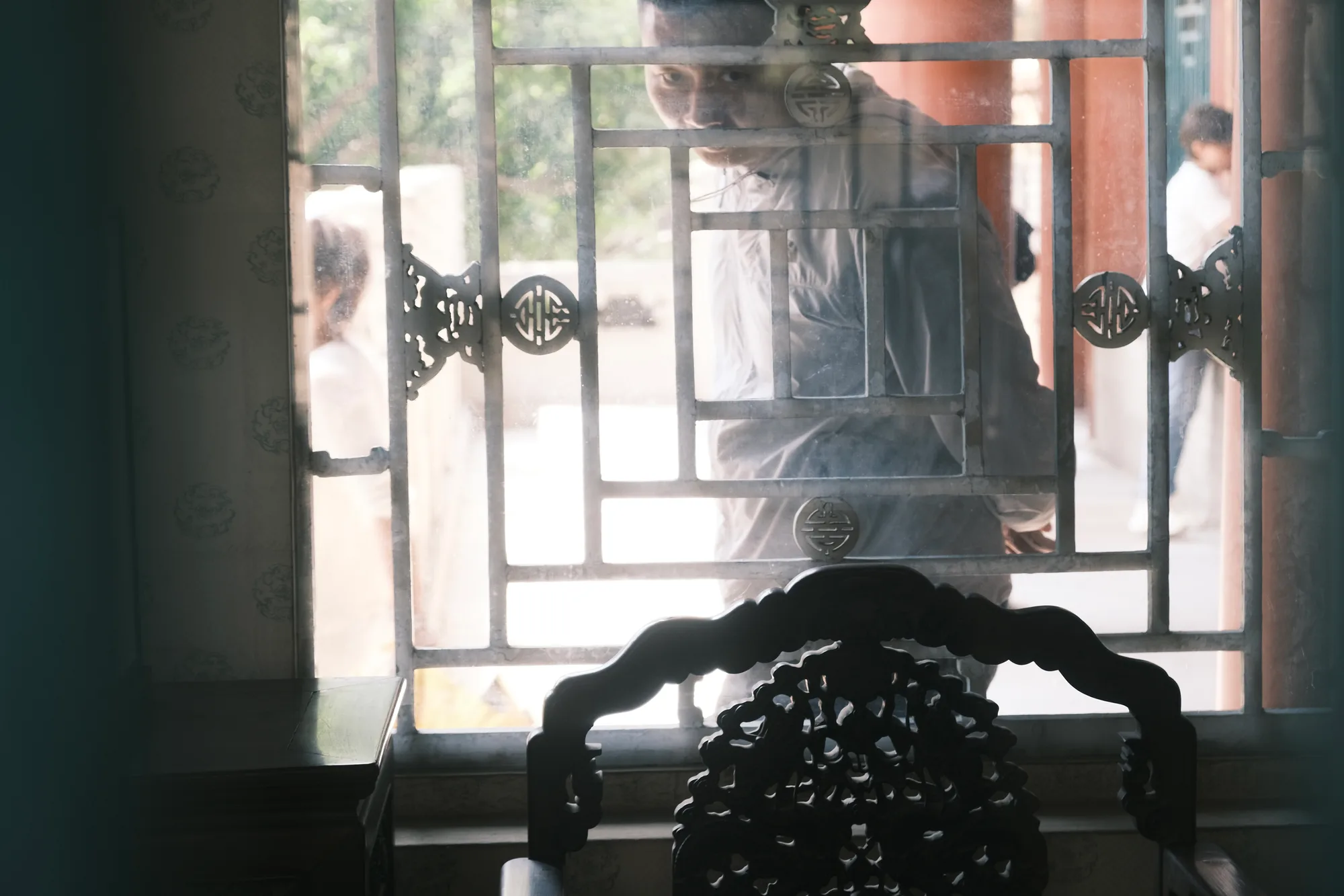 A dim portrait framed by a window.