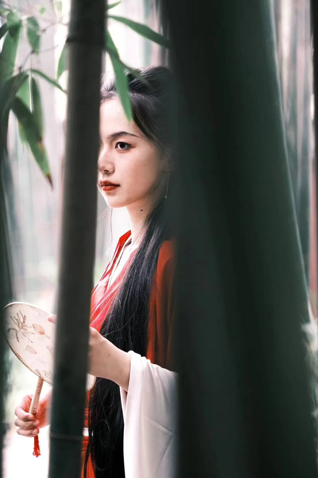 A portrait behind deep green foliage.